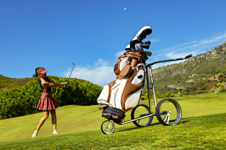 JuCad Trolley in Braun/Weiß mit Golfbag auf dem Golfplatz